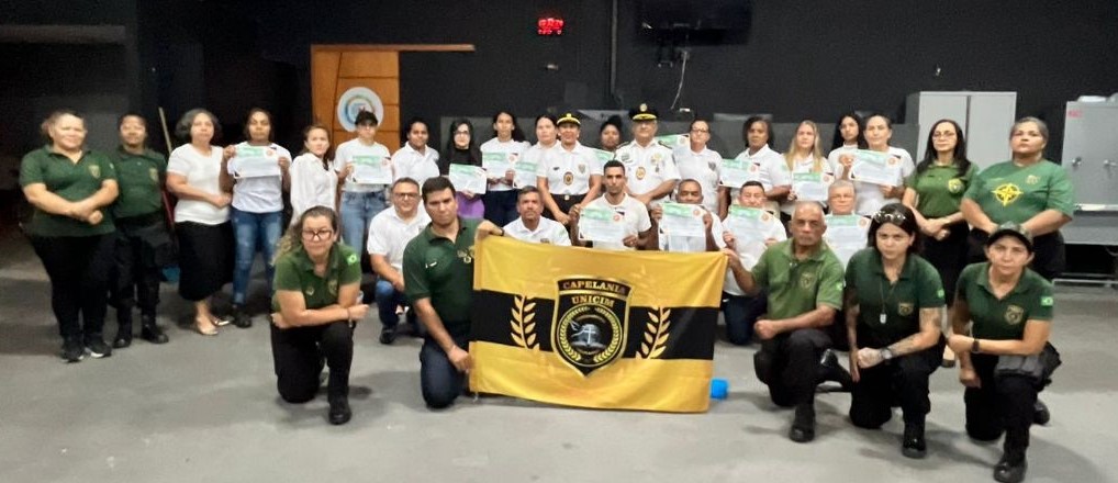 Turma UNICIM com bandeira em farda operacional
