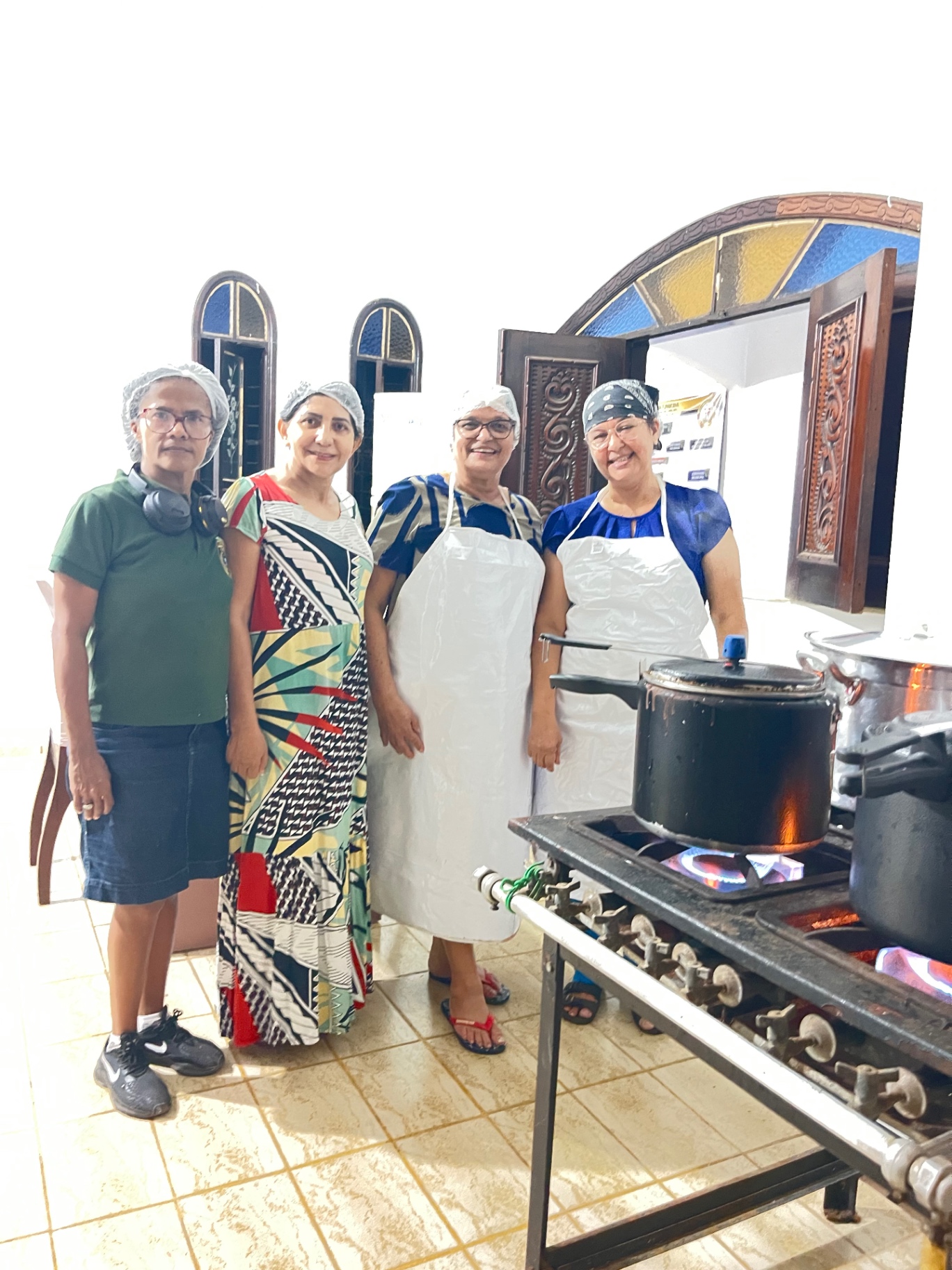 Equipe voluntária preparando refeições na cozinha solidária